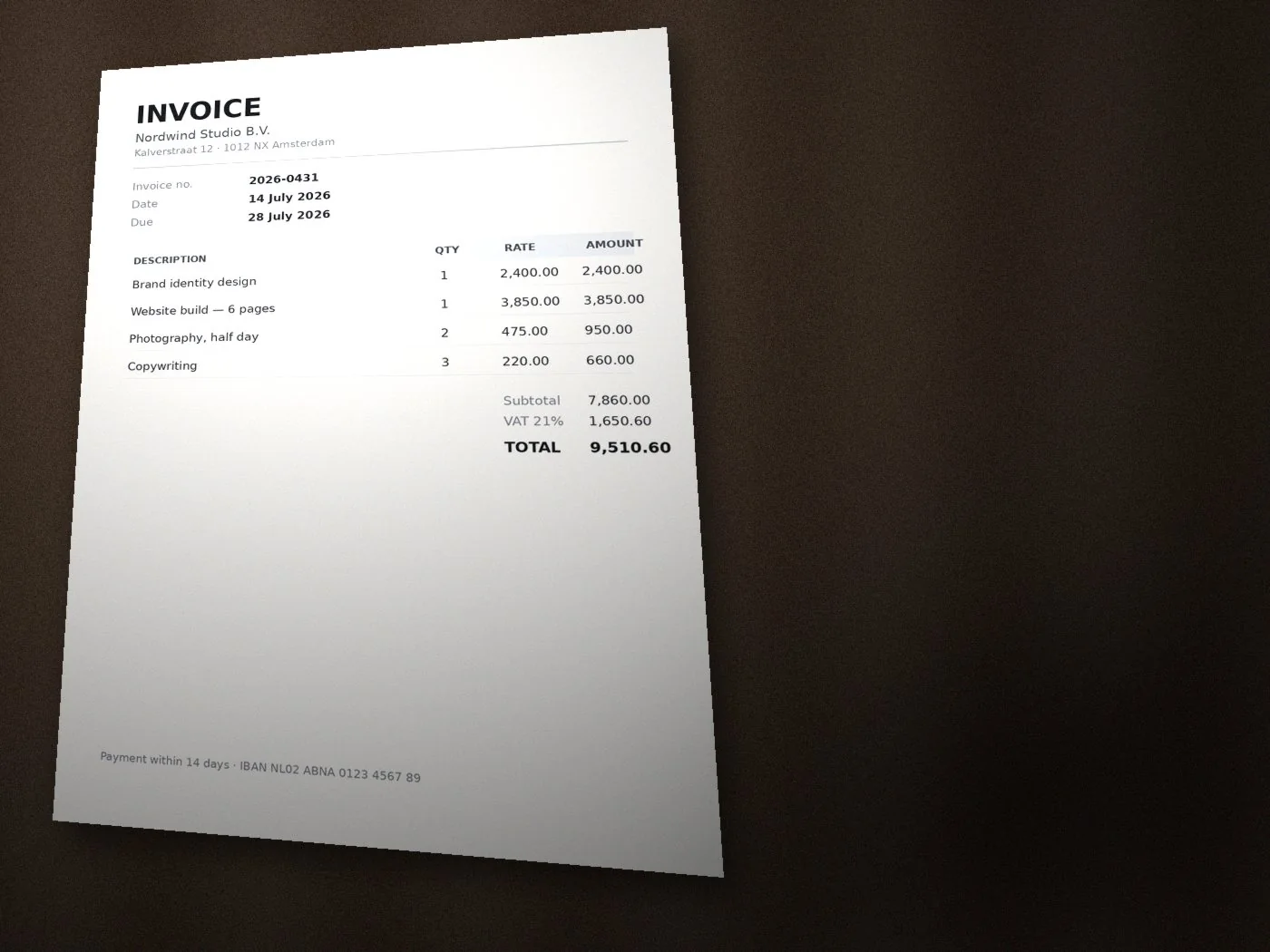 Photo of an invoice lying skewed on a dark desk, with a shadow across the page